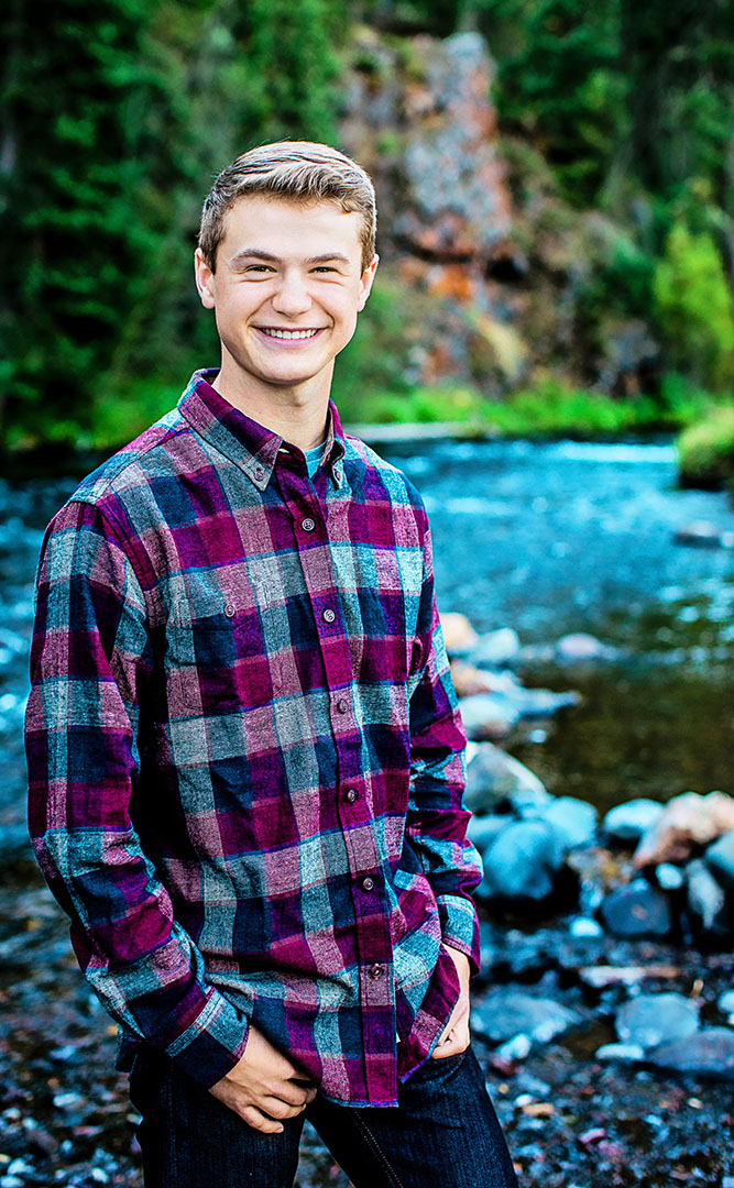 Smiling young man in front of a river.